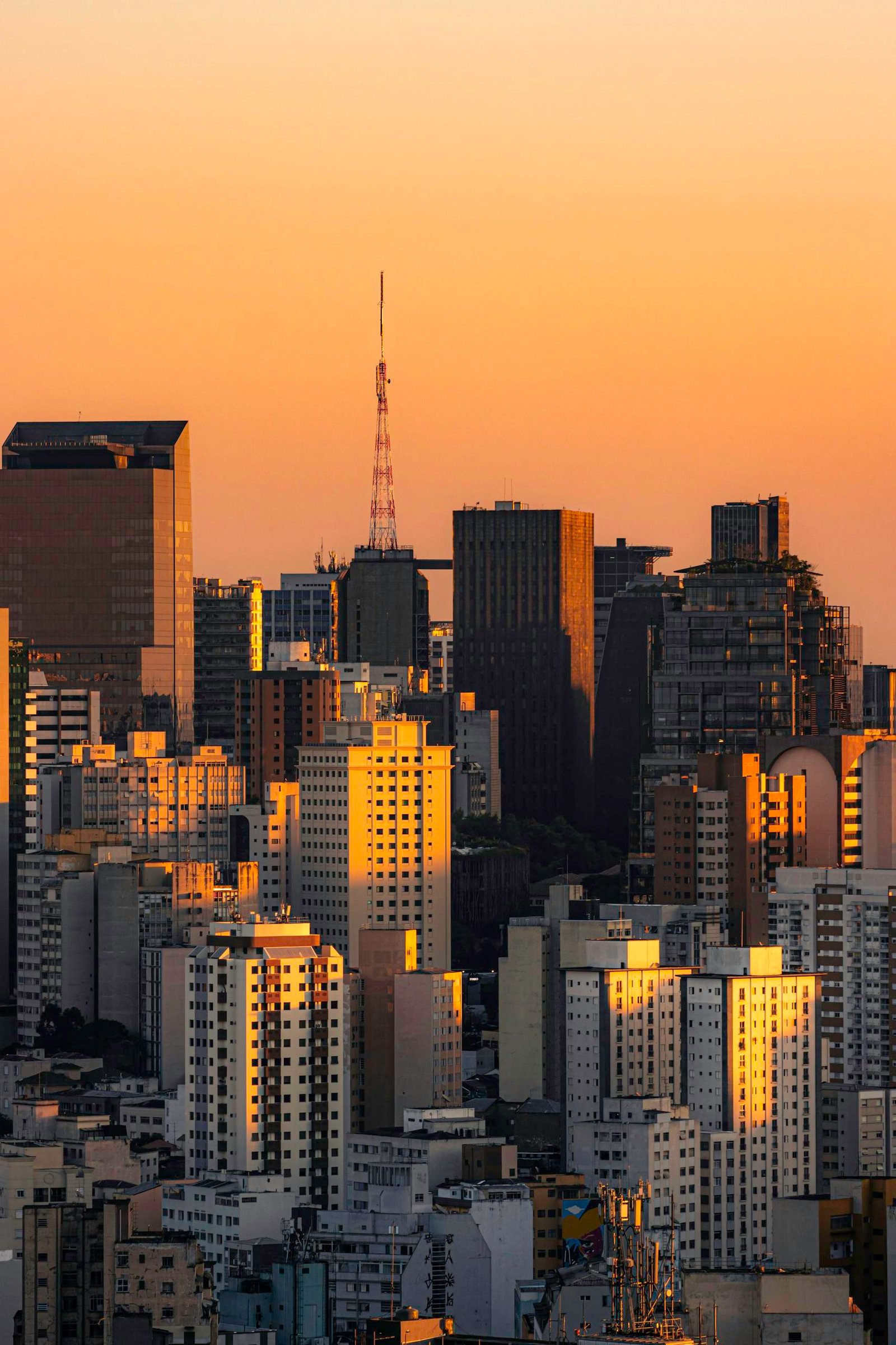 Dramatic sunset over São Paulo's skyline highlights modern architecture and vibrant city life.