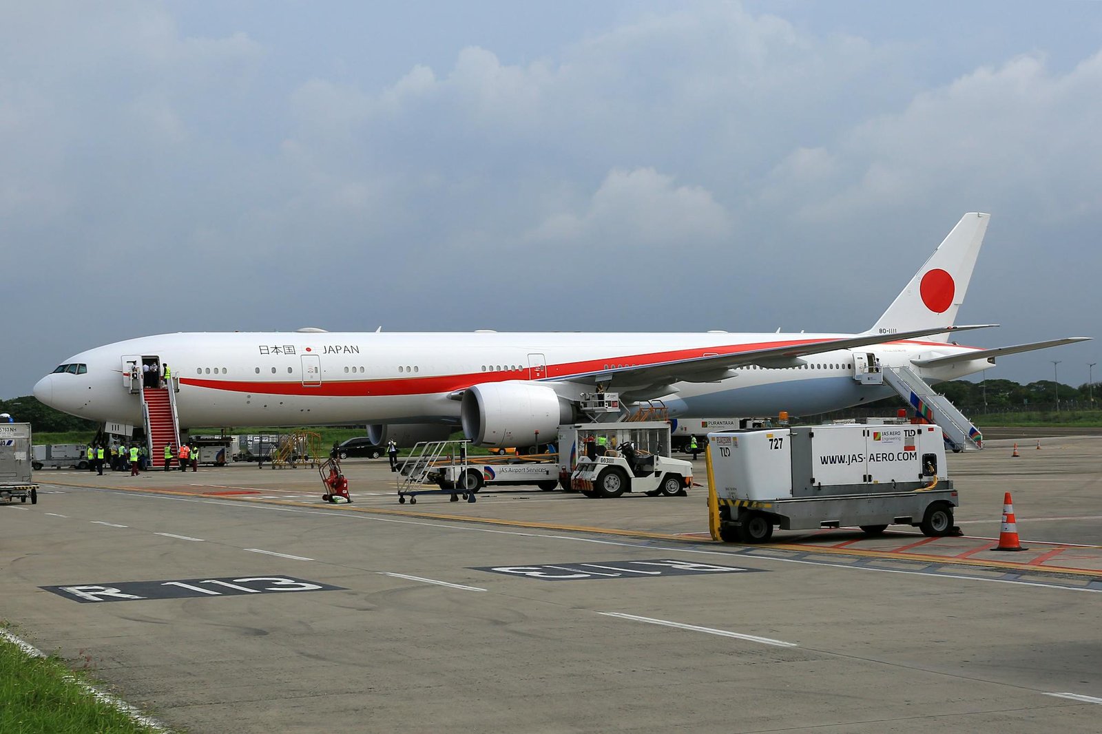 Japanese Government airplane parked on tarmac, preparing for departure.