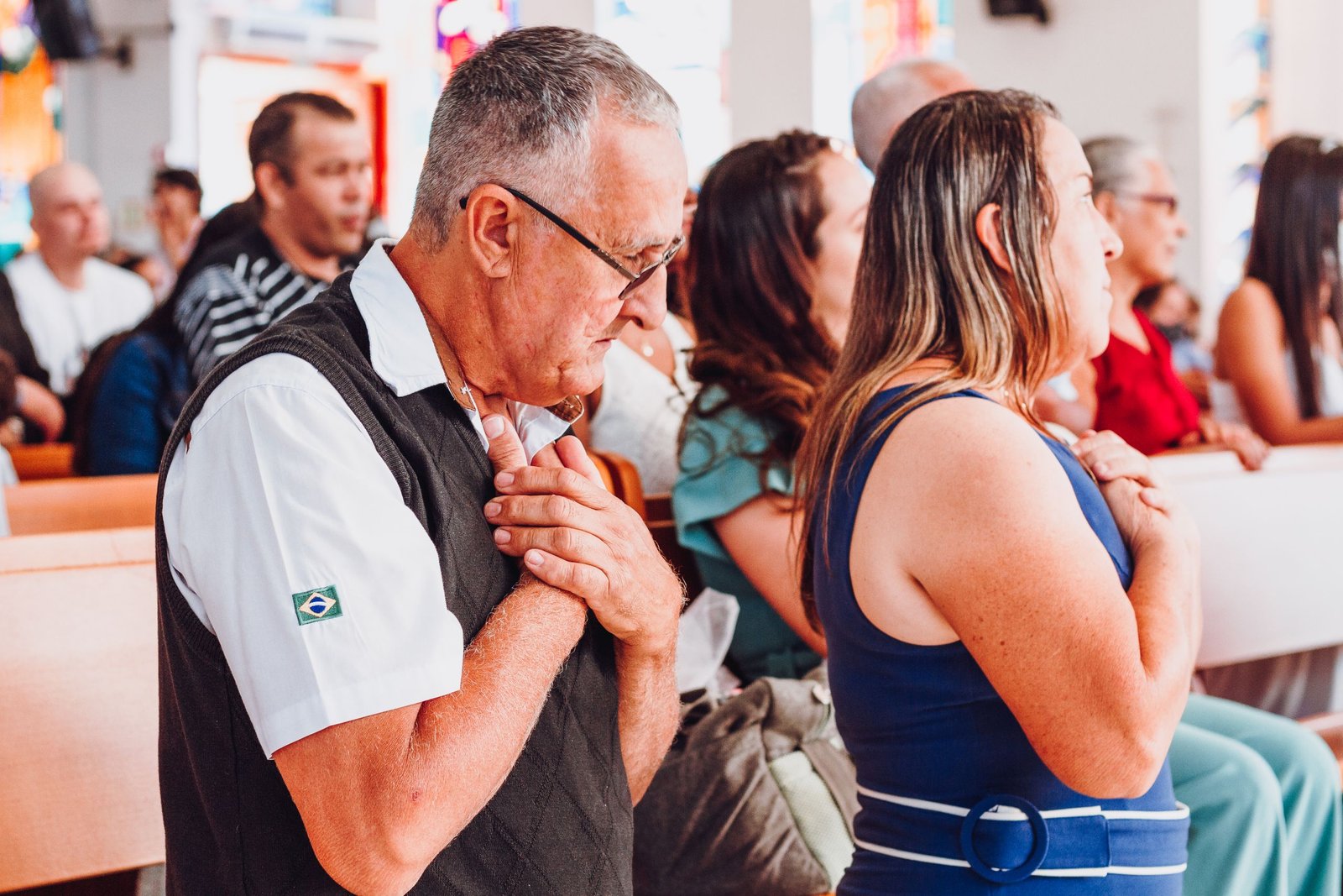 A diverse group of adults in prayer inside a church, expressing spirituality and devotion.