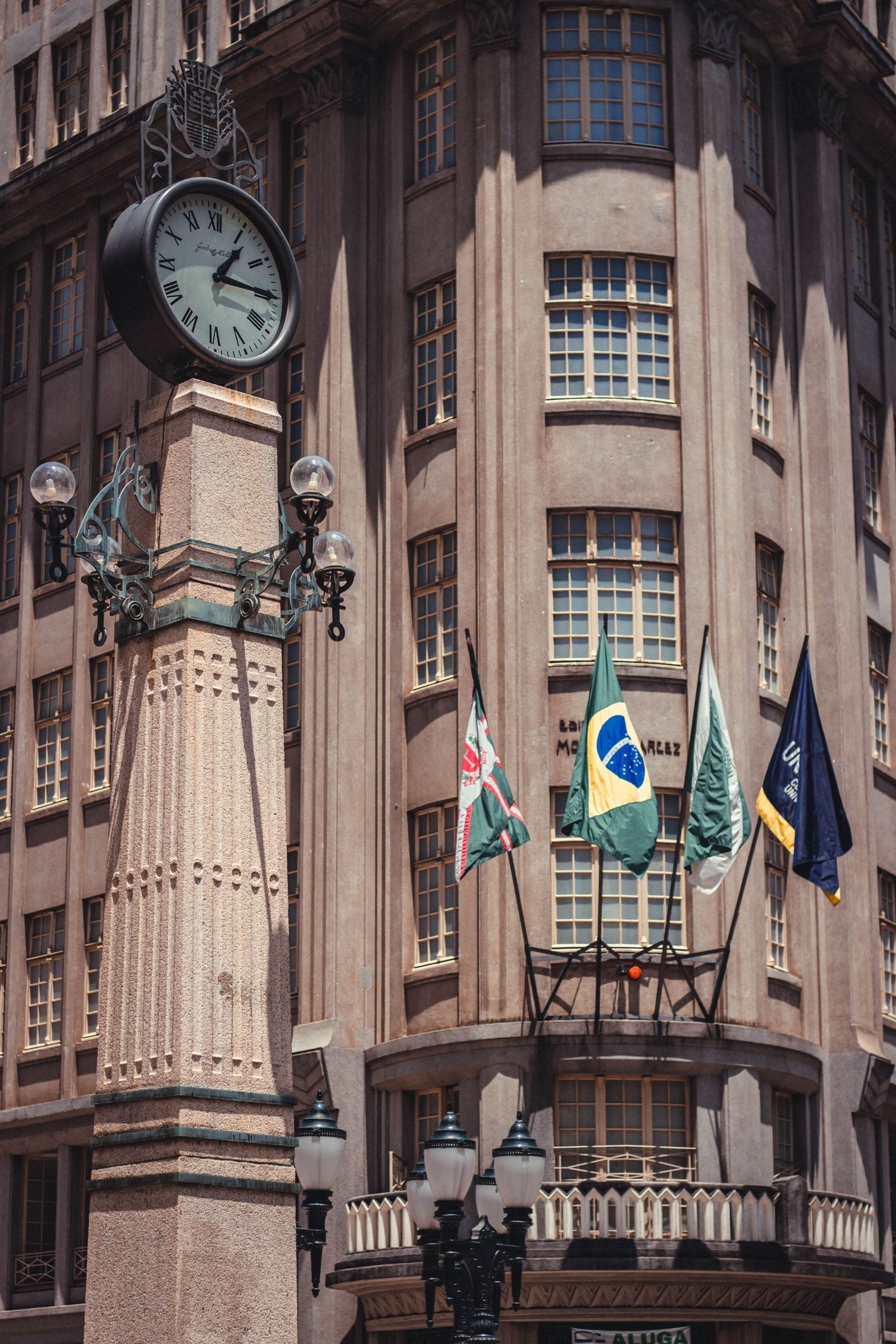 Facade of Edifício Moreira Garcez with clock tower and flags, Curitiba, Brazil.
